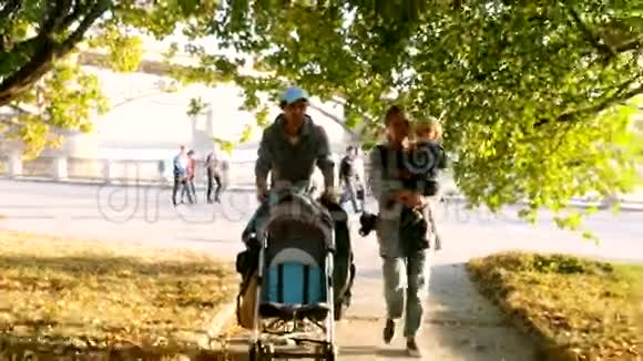 带着孩子的家人穿过秋天的公园3840x2160视频的预览图