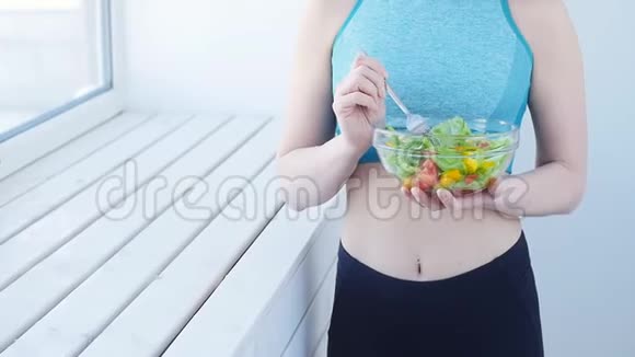 健康的饮食观念运动后吃健康沙拉的年轻女性视频的预览图