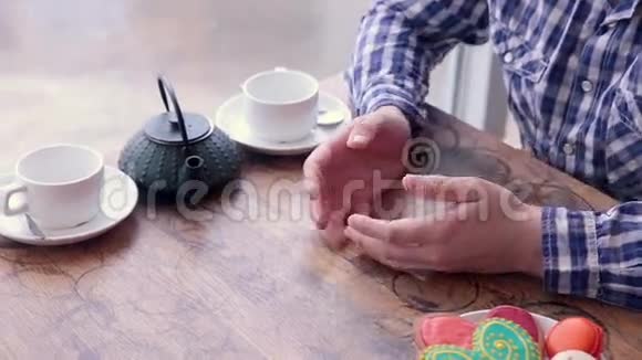 一对幸福的恋人轻抚揉搓桌上有饼干和茶视频的预览图