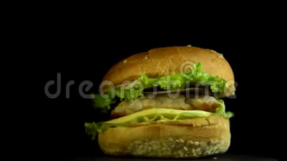 美味的芝士汉堡在黑色背景上旋转视频的预览图