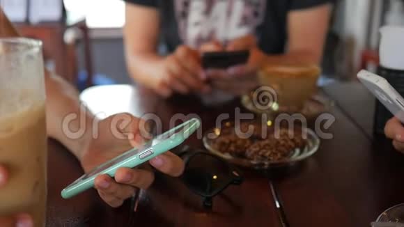 坐在咖啡馆里聊天和使用手机的年轻朋友小组视频的预览图