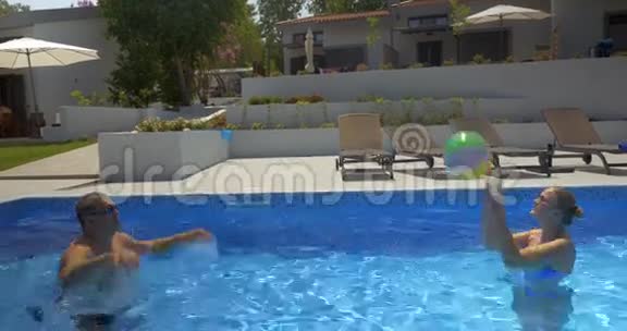 男人和女人在游泳池里打球视频的预览图