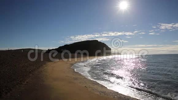 英国西湾侏罗纪海岸多塞特清晨阳光照耀着波光粼粼的海面远处的人们在游泳视频的预览图
