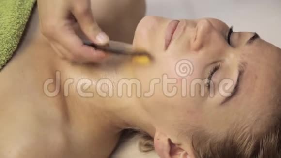 美丽的女人有一个穴位按压的脸与刮刀沟中国替代疗法视频的预览图