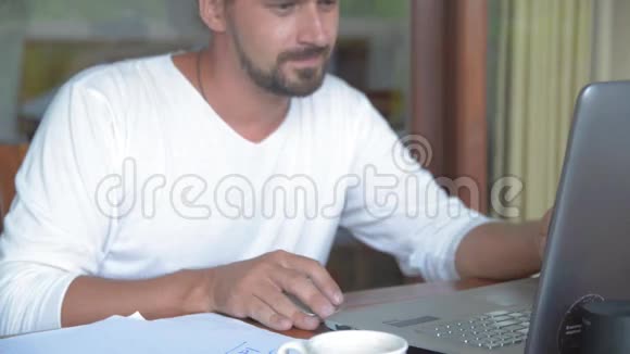 一个商人在读一本计划书和一个思考的想法时用手提电脑工作视频的预览图