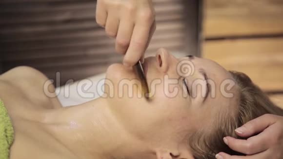 美丽的女人有一个穴位按压的脸与刮刀沟中国替代疗法视频的预览图