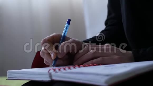 悲伤的年轻女子坐在床上写日记青少年的经历慢动作视频的预览图
