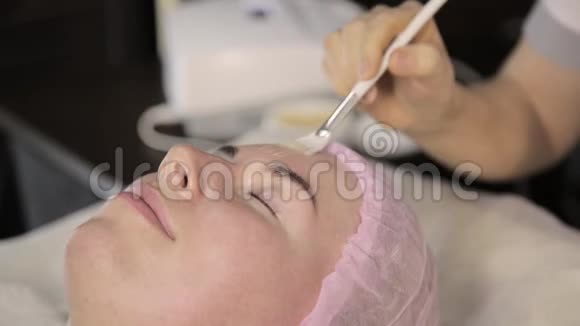 美容师为一个在美容院的女人做射频面部提升程序硬件美容视频的预览图