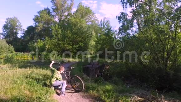 少年骑自行车男孩检查他的自行车很快男孩就会骑自行车去了视频的预览图