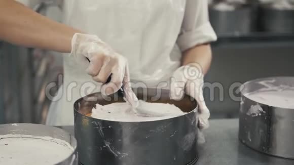 女厨师用橡胶手套做饭准备香草蛋糕混合面团用于烘焙蛋糕年轻的面包师视频的预览图