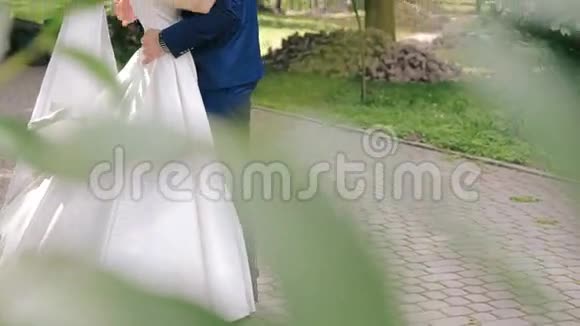 新婚夫妇拥抱在公园的小巷里视频的预览图