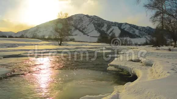 河流流动在夕阳下闪闪发光在山里寒冷的冬天视频的预览图