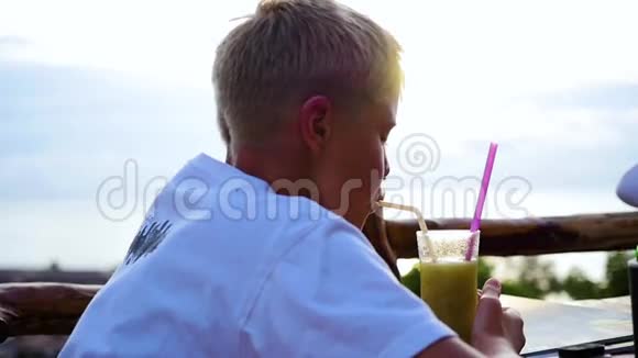 一个年轻人在咖啡馆的露台上喝鸡尾酒在户外视频的预览图