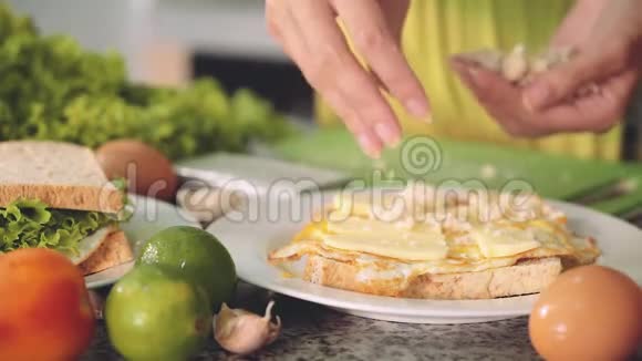 女人用鸡蛋奶酪鸡肉和绿色沙拉做三明治视频的预览图