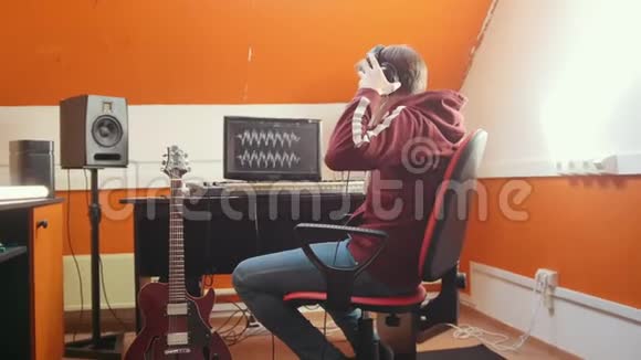 一个戴着耳机的人在录音室弹吉他视频的预览图