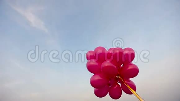 在蓝天背景下红色的气球在微风中摇曳视频的预览图