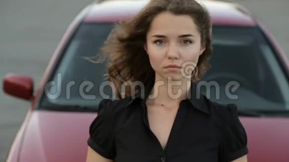 戴墨镜的女孩在红车背景下摆姿势视频的预览图