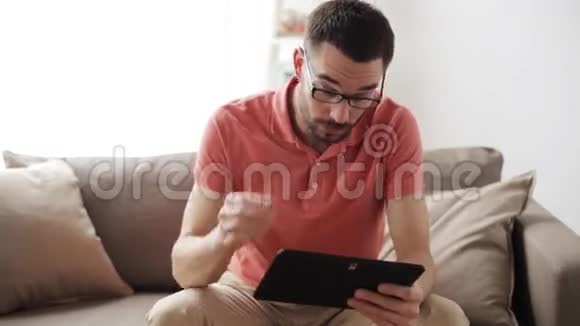 一个带平板电脑的人在家里戴着眼镜视频的预览图
