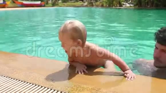 小女孩从游泳池里爬出来爸爸很高兴视频的预览图