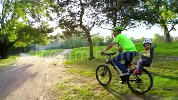 父亲和小儿子在绿茵中骑自行车视频的预览图
