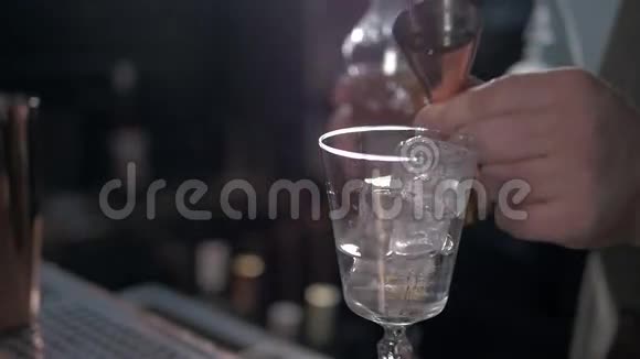 酒保正在酒吧柜台做鸡尾酒在摇床里加入一些苦味视频的预览图