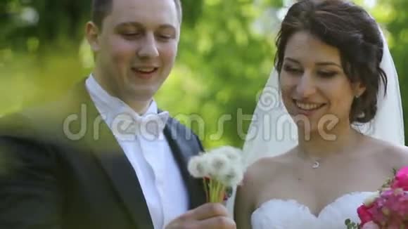 新婚夫妇吹在蒲公英上视频的预览图