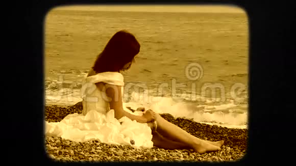 美丽的女人坐在沙滩上视频的预览图