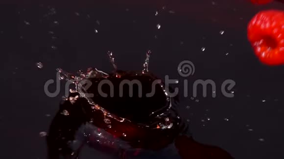 成熟的红树莓落入果汁中视频的预览图