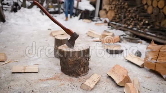 伐木工人在雪地里用斧头砍木头视频的预览图