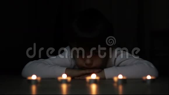 小男孩在黑暗中看着我们蜡烛视频的预览图
