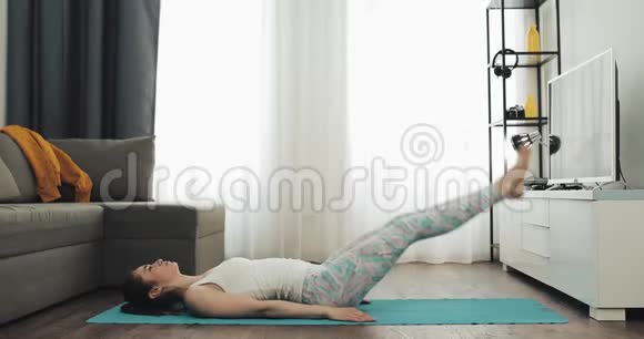 在家做瑜伽的年轻女人健康和运动的生活方式视频的预览图