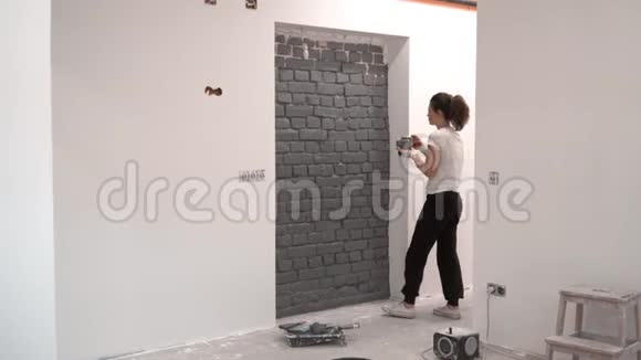 女孩用刷子粉刷砖墙视频的预览图