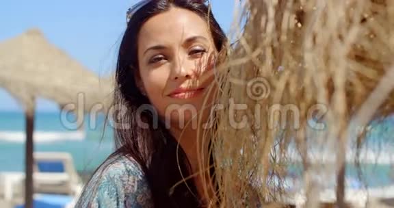 美丽的女士把头靠在沙滩伞上视频的预览图