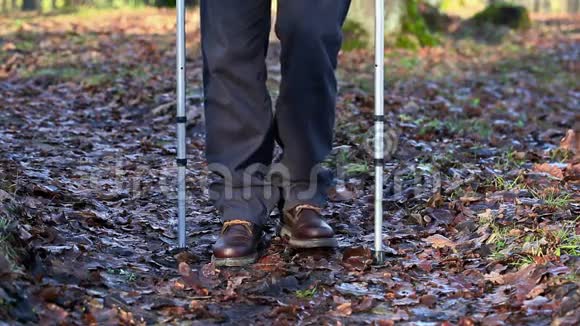 残疾人拄着拐杖在户外公园的小径上秋叶视频的预览图
