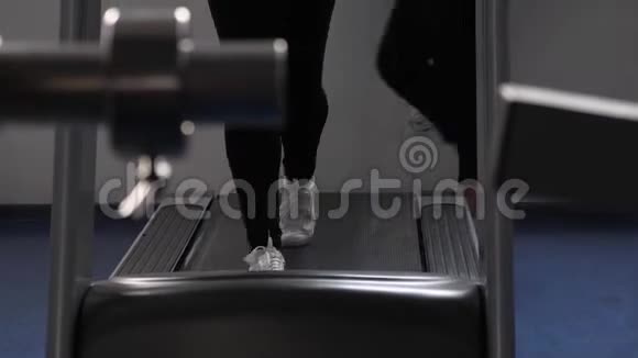 通过走路加强腿部肌肉特写镜头在健身房散步心脏负荷女孩在跑步机上训练健身健身视频的预览图