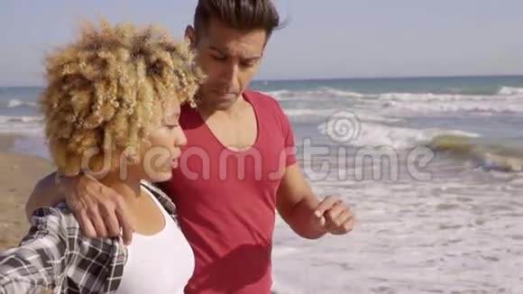 站在海滩上的年轻混血夫妇视频的预览图