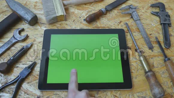 男手工匠使用平板电脑与绿色屏幕在车间上景不同的老式工具视频的预览图