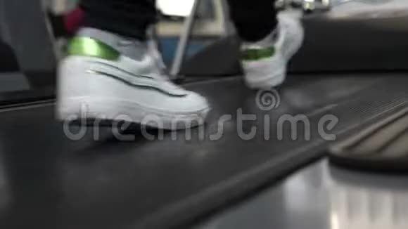 通过走路加强腿部肌肉特写镜头心脏负荷女孩在跑步机上训练在健身房散步健身健身视频的预览图