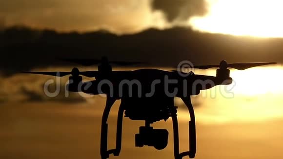 在灿烂的夕阳下一只带旋转叶片的飞行四翼飞机视频的预览图