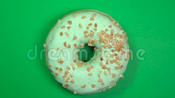 美味新鲜的甜甜圈特写镜头旋转在绿色背景上视频的预览图
