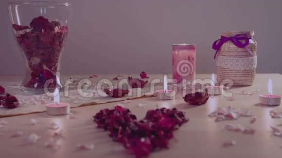 浪漫的装置在桌子上燃烧蜡烛心形的花壶倒视频的预览图