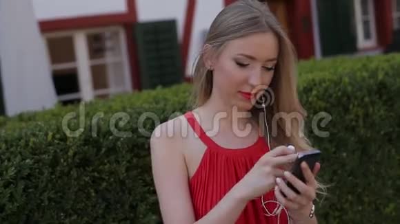 年轻女孩通过你的手机听音乐应用程序视频的预览图