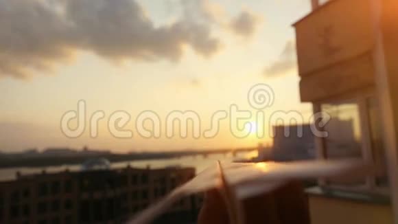 女人的手纸飞机在日落与太阳耀斑在缓慢的运动在童年的城市背景贷款视频的预览图