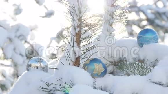 雪覆盖的冷杉树枝上的圣诞球视频的预览图
