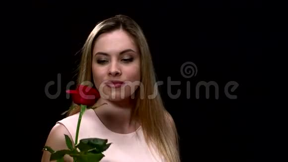靠近女人用封闭的方式嗅着红玫瑰视频的预览图