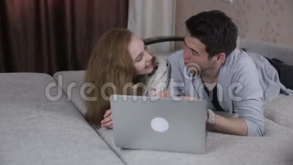 年轻夫妇在室内共用一台笔记本电脑视频的预览图