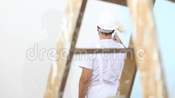 油漆工在工作有滚筒油漆墙木梯在附近视频的预览图