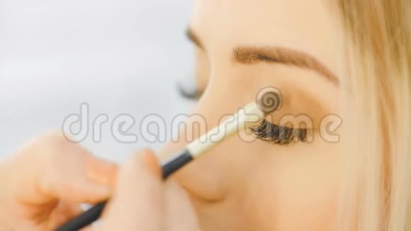 专业眼妆师应用眼影粉漂亮的女人脸完美的妆容美容时尚视频的预览图