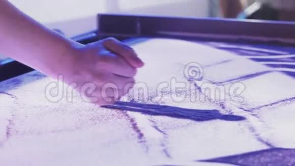 女人的手指在沙滩上画出美丽的家庭画面艺术照明视频的预览图