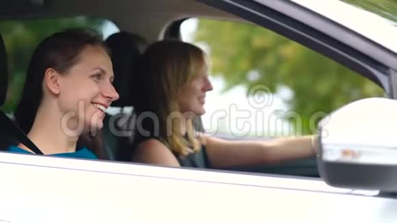 两个年轻的女人坐在车里玩得很开心慢动作视频的预览图